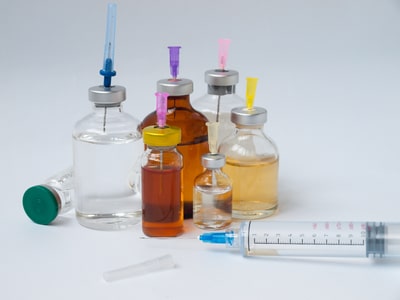 A large syringe and vials of medicine