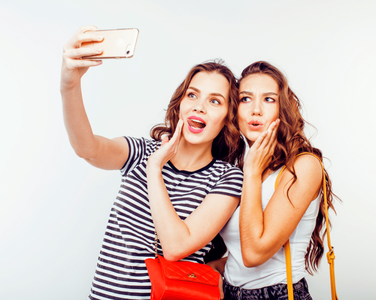 2 young girls making faces while taking a selfie