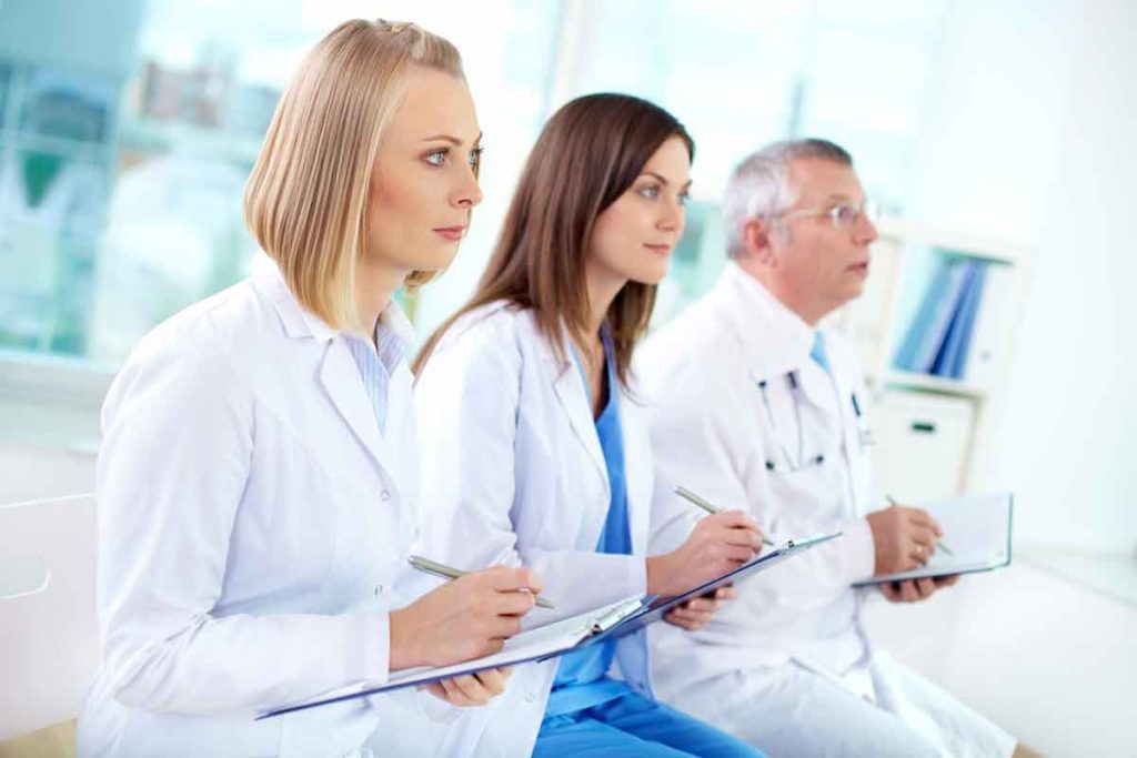 3 nurses at lecture taking notes