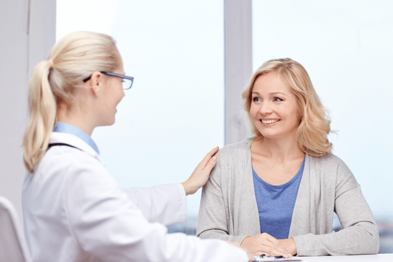 Female patient being happily reassured by female physician
