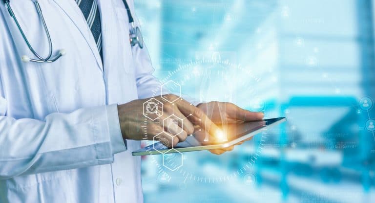 Medical professional using finger to tap on a electronic notepad with very faint symbols in foreground
